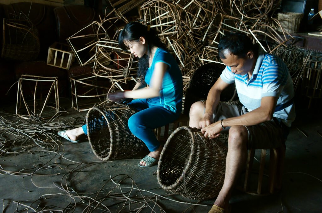 Vietnamese worker working inside of home at trade village to make traditional product, rattan basket from nature material, clever hand, Vietnam, May1, 2015 / Source: xuanhuongho - YayImages